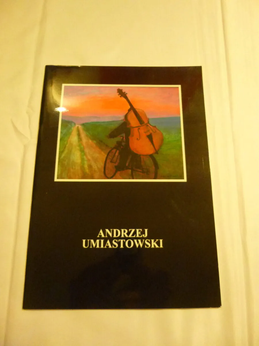 Couverture du catalogue d'art broché de l'artiste peintre polonais Andrzej Umiastowski montrant un homme à vélo transportant une contrebasse au coucher du soleil