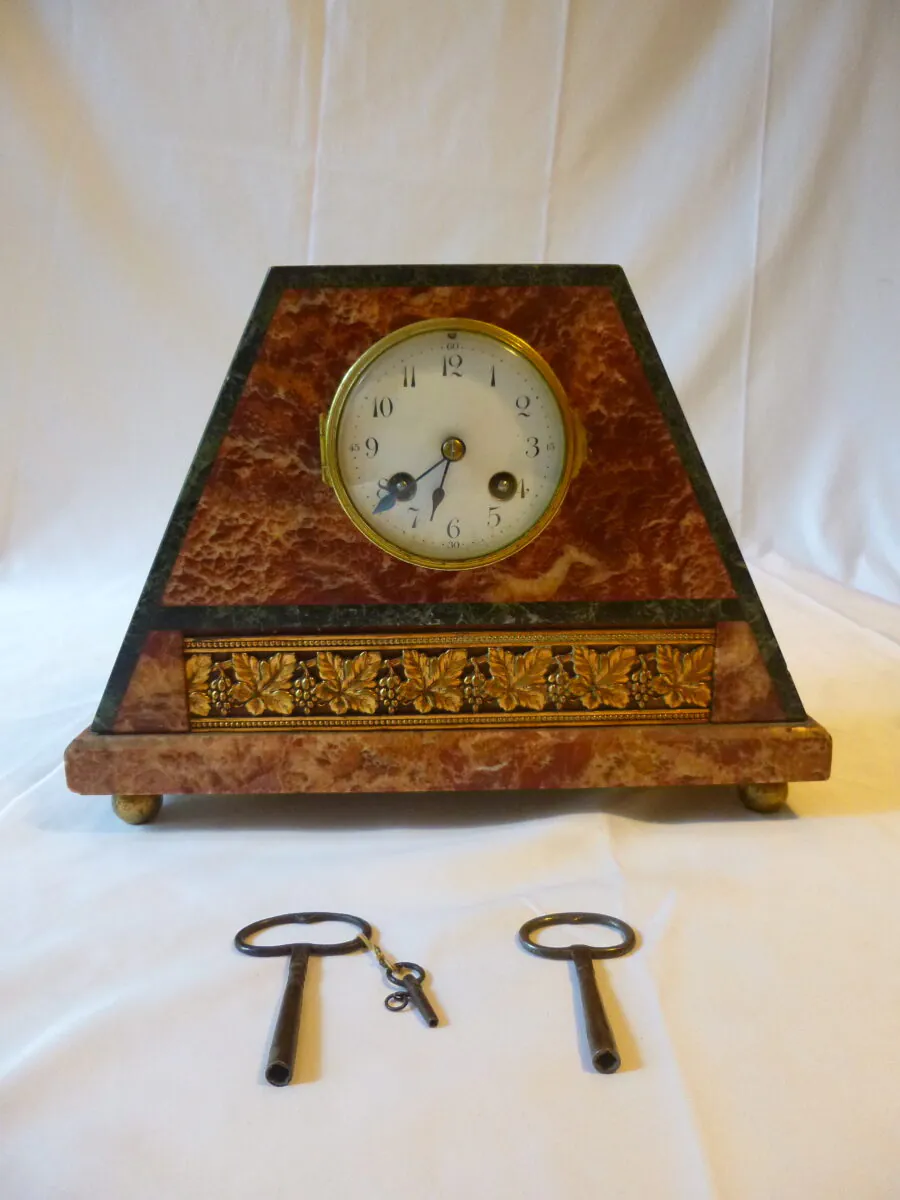 Horloge Art Déco en marbre rouge avec frise en bronze doré et ses deux clés de remontage